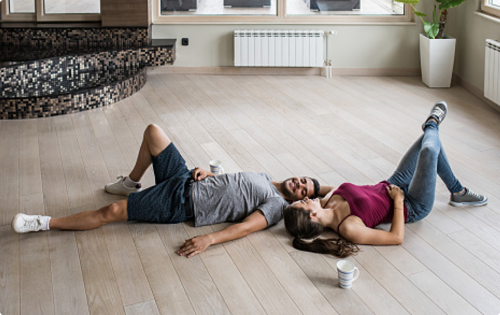 Couple relaxing on light wood flooring for interior design inspiration